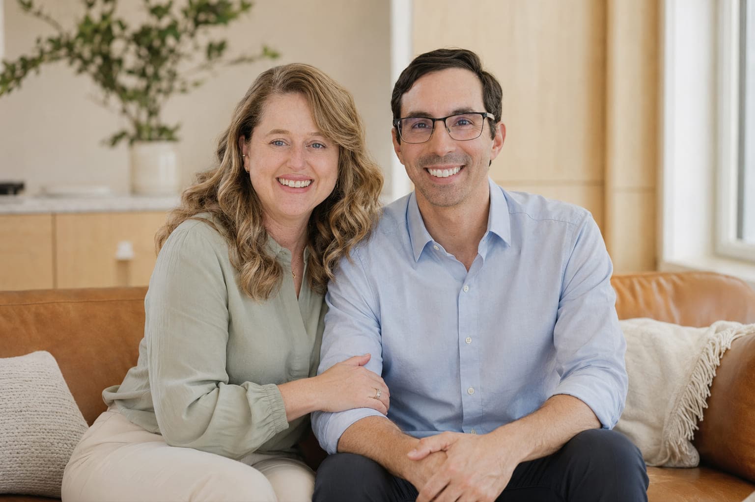 Nichole and Steve DiPippo, co-founders of Salto Strategic Advisors, sitting together on a couch.